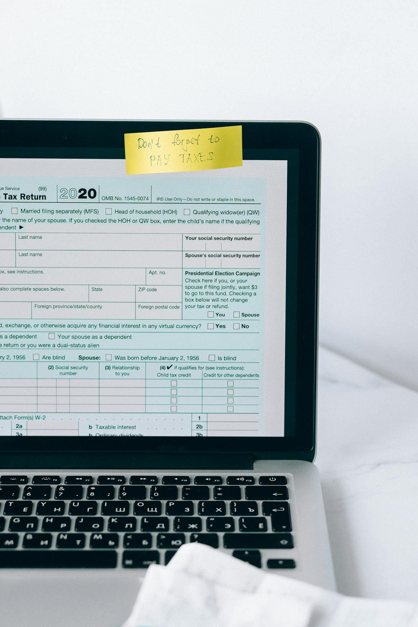 Laptop showing tax form with a reminder note, emphasizing tax payment.